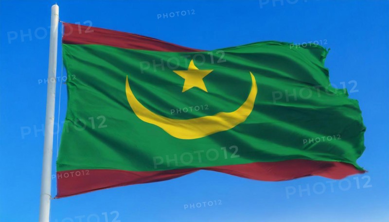 The flag of Mauritania, Mauritania, flutters in the wind, isolated against a blue sky, Africa