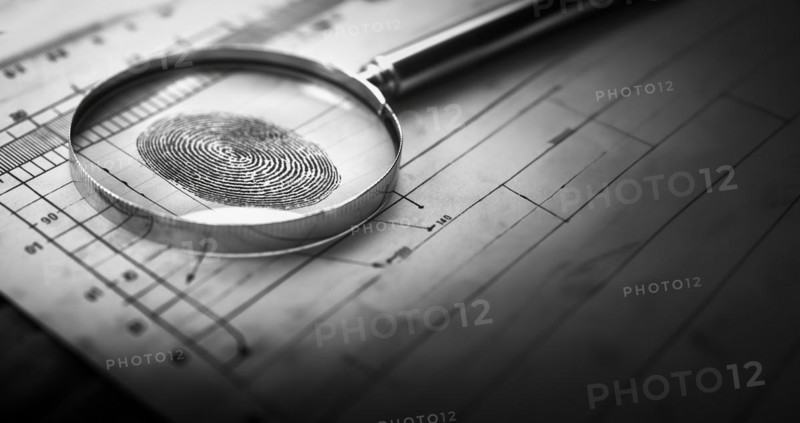 Magnifying glass resting on a fingerprint on paper. generative AI, AI generated