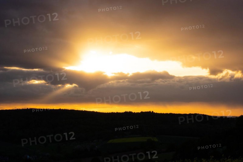 Landscape at sunrise. Beautiful morning landscape with fresh yellow rape fields in spring. Small castle in the yellow fields on a hill. Historic Ronneburg Castle in the middle of nature, Ronneburg, Hesse, Germany, Europe