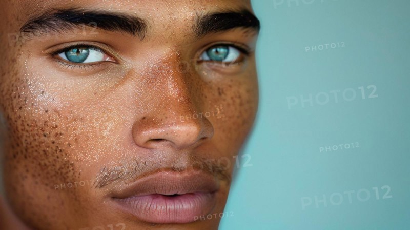 Close-up of a male with freckles and intense blue eyes, blurry teal turquoise solid background, beauty product studio lightning, fashion artsy make up, high concept potraiture, AI generated