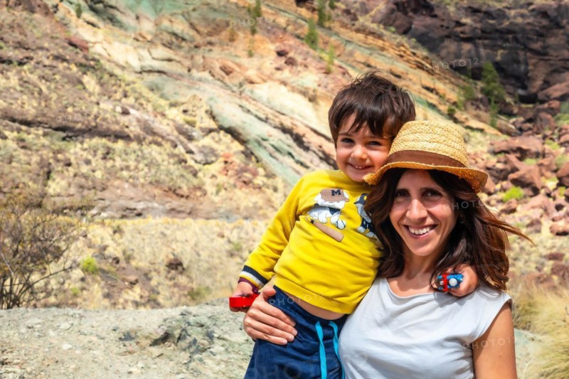 Portrait of mother and son enjoying at the Natural Monument Azulejos de Veneguera or Rainbow Rocks in Mogan, Gran Canaria