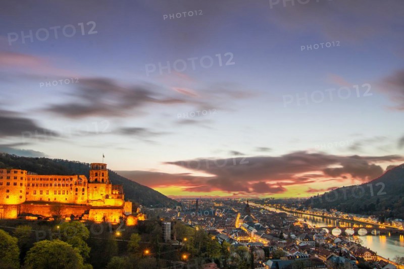 View over an old town with castle or palace rune in the evening at sunset. This town lies in a river valley of the Neckar, surrounded by hills. Heidelberg, Baden-Wuerttemberg, Germany, Europe