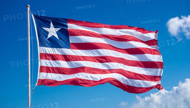 The flag of Liberia, fluttering in the wind, isolated, against the blue sky