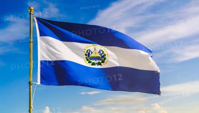 The flag of El Salvador flutters in the wind, isolated against a blue sky