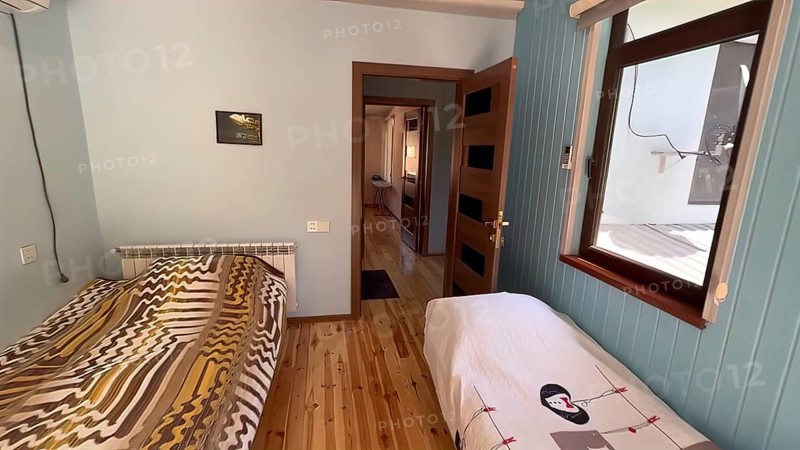 Interior of a hotel room with a double bed and wooden floor
