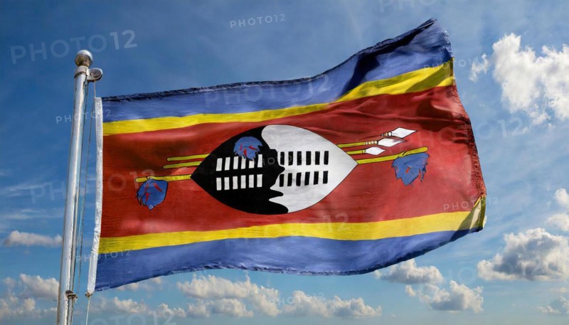 The flag of Swaziland, Kingdom of Eswatini, flutters in the wind, isolated, against the blue sky