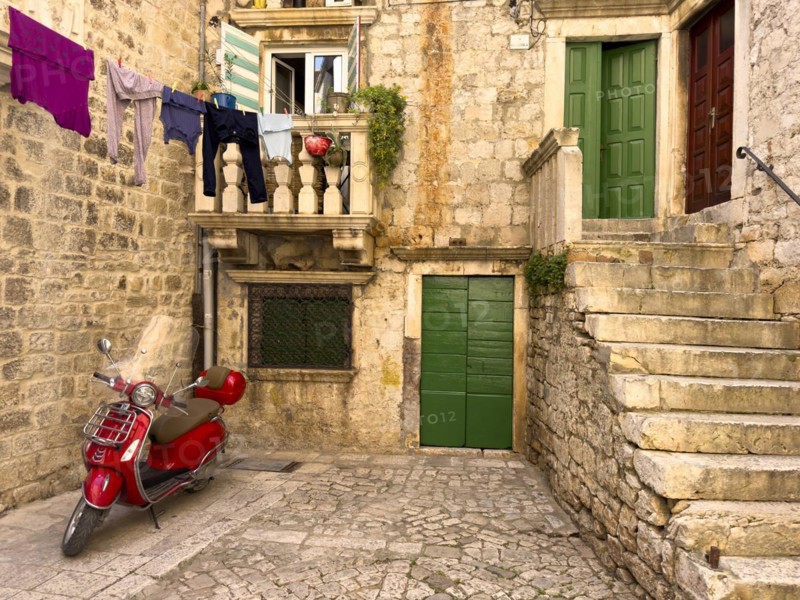 Red Vespa under a washing line in front of a traditional house, Trogir, Dalmatia, Croatia, Europe