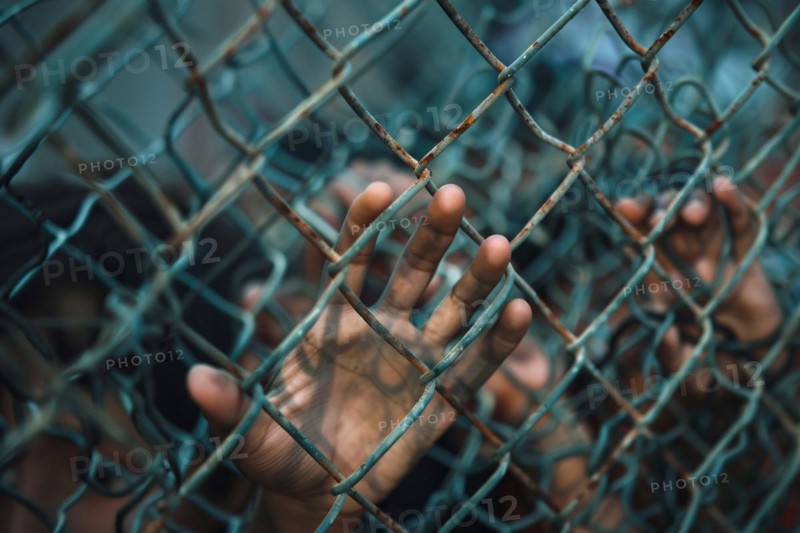 Hand of desperate immigrant on chain link fence. KI generiert, generiert, AI generated