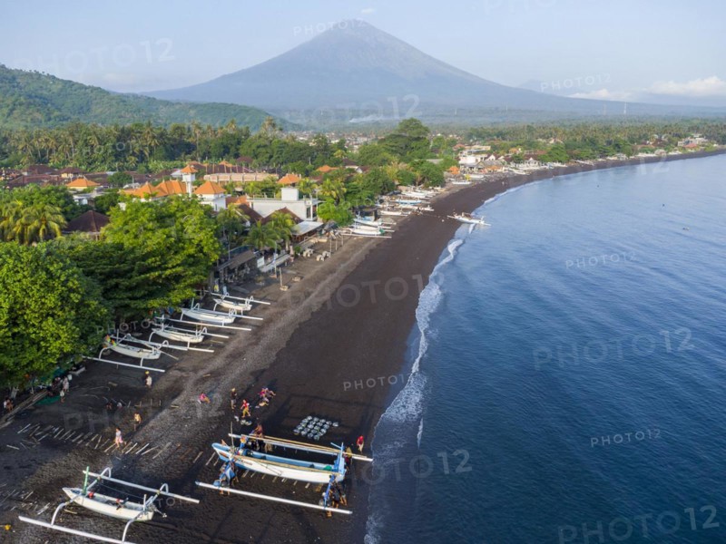 Fishermen unload their catch from their outrigger boat in the morning, in the background Gunung Agung, Amed, Karangasem, Bali, Indonesia, Asia