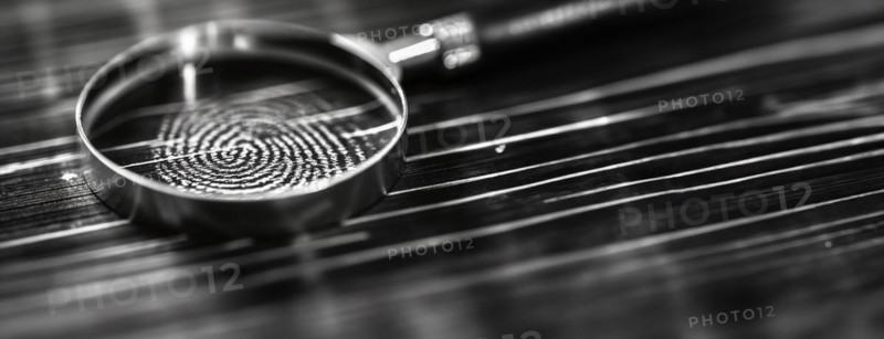 Banner of magnifying glass resting on a fingerprint on paper. generative AI, AI generated