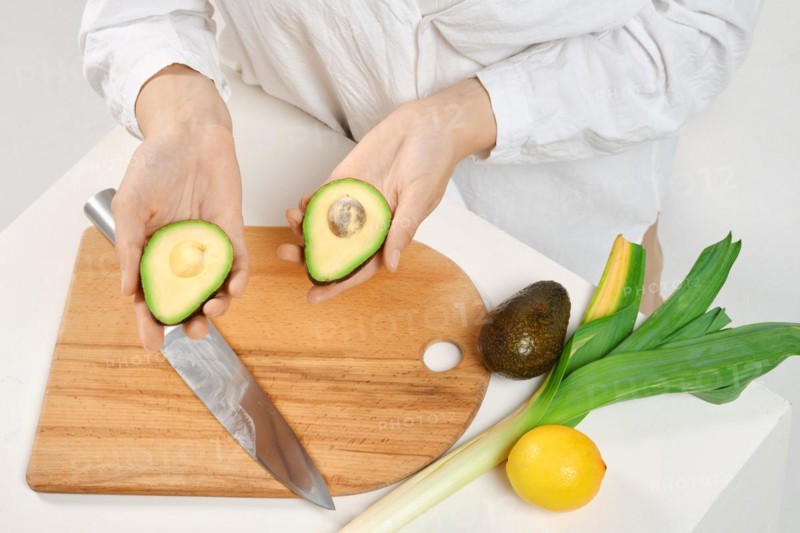 Unrecognizable woman holding avocado halves in her hands