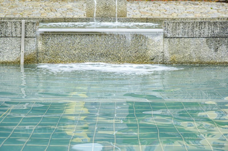 Water flows over the overflow of a water basin into another basin