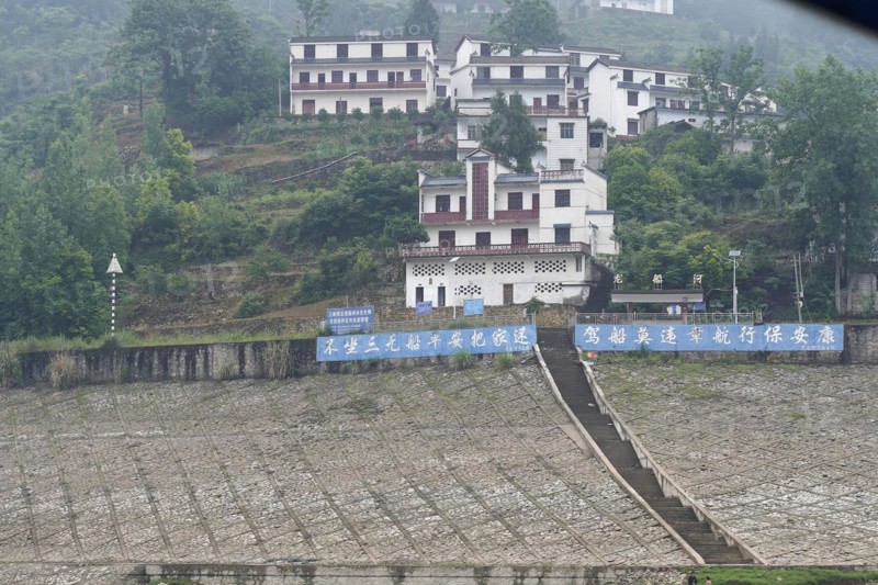 Cruise ship on the Yangtze River, Hubei Province, China, Asia, White building with blue accents stands on the lowered bank wall, Yichang, Asia