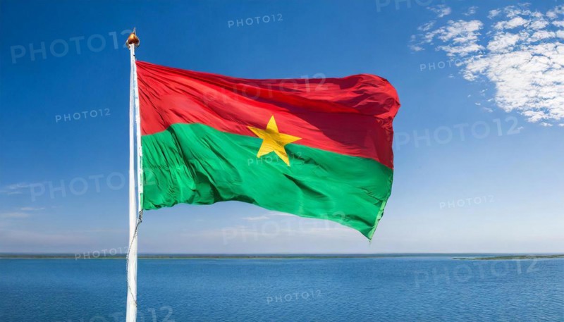 The flag of Burkina Faso flutters in the wind, isolated against the blue sky