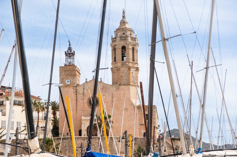 Beach, promenade with view of the church of St Bartholomew and St Thekla in Sitges, Spain, Europe