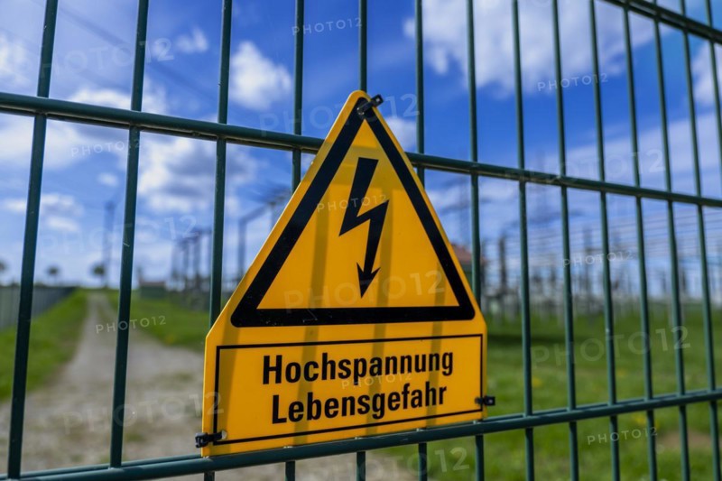Yellow warning sign with the inscription Hochspannung Lebensgefahr! on a fence of the Avacon substation Helmstedt, Helmstedt, Lower Saxony, Germany, Europe