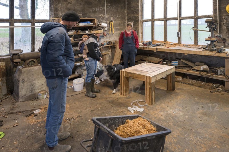 Family inspecting the table built by their son in the workshop, Mecklenburg-Vorpommern, Germany, Europe