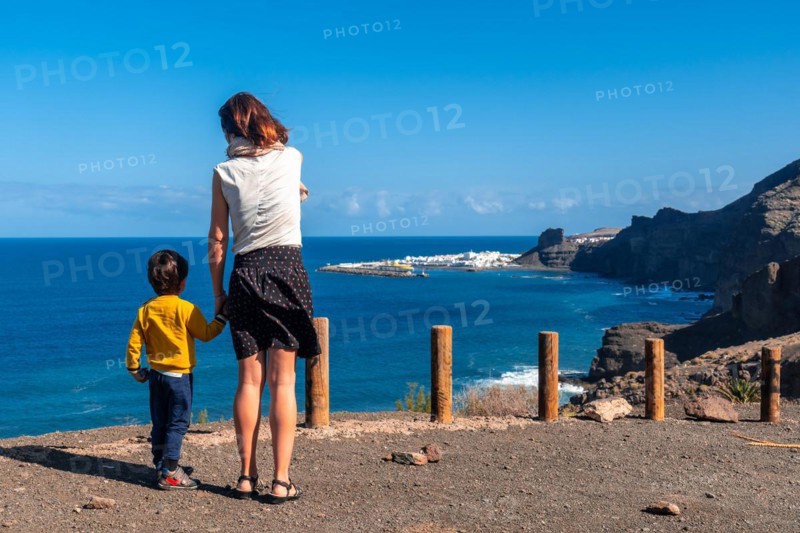 A mother and her son looking at Agaete from the Barraco de Guayedra viewpoint. Gran Canaria. Spain