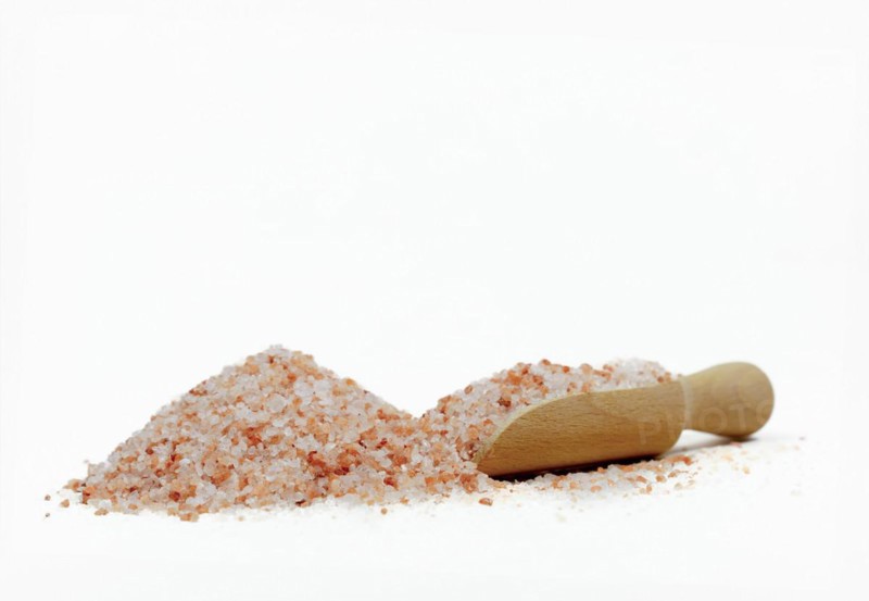 Wooden spoon with pink himalayan salt isolated on white background and copy space