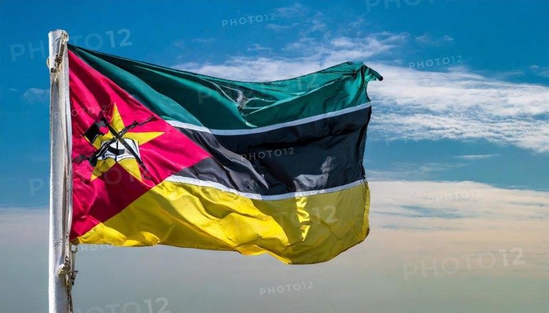 The flag of Mozambique, fluttering in the wind, isolated, against the blue sky