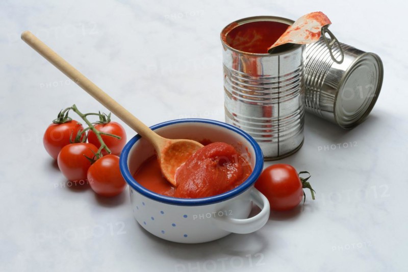 Tinned tomatoes in a bowl, tin can and tomatoes
