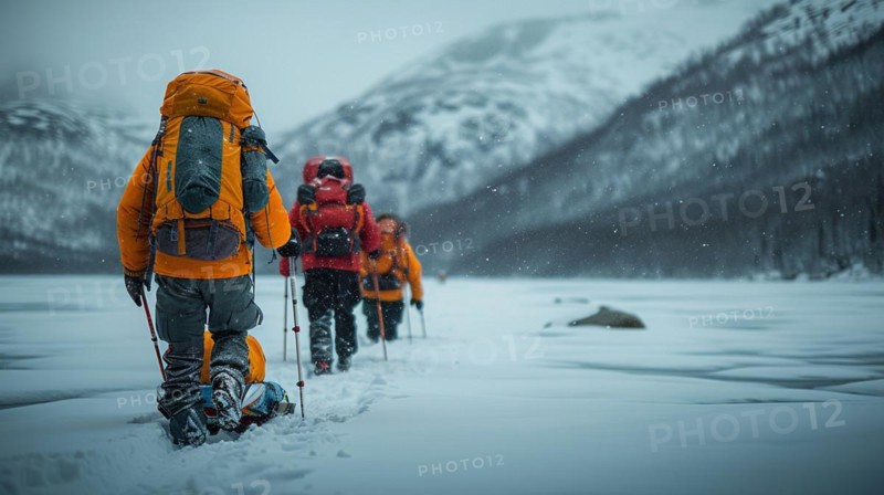 Trekkers in yellow jackets moving through a snowy landscape with mountains in the distance, AI generated