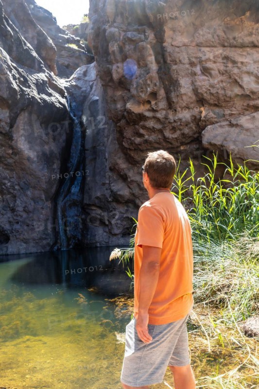 A man looking at the waterfall at Charco Azul in El Podemos a Agaete on Gran Canaria, Canary Islands