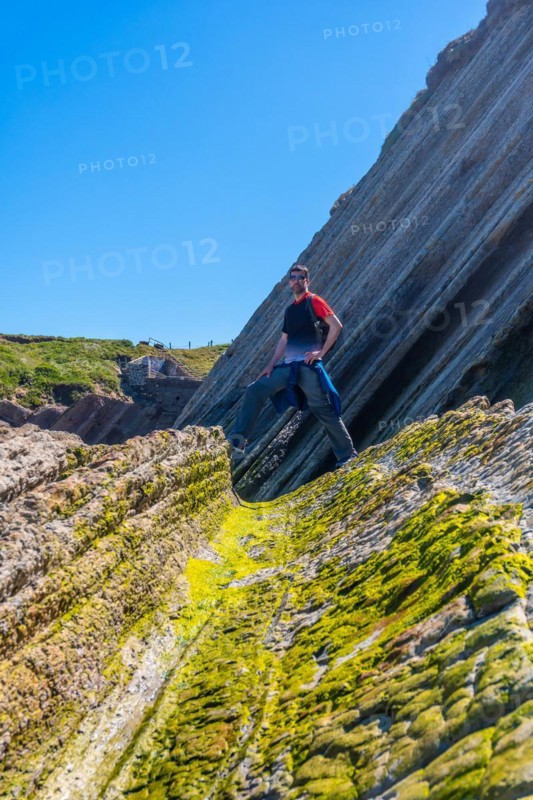 A tourist hiker visiting the Flysch Basque Coast geopark in Zumaia, Gipuzkoa