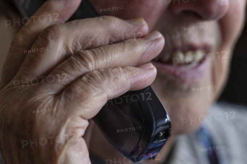 Mouth, hands and telephone receiver of a senior citizen making a phone call, close-up, Cologne, North Rhine-Westphalia, Germany, Europe