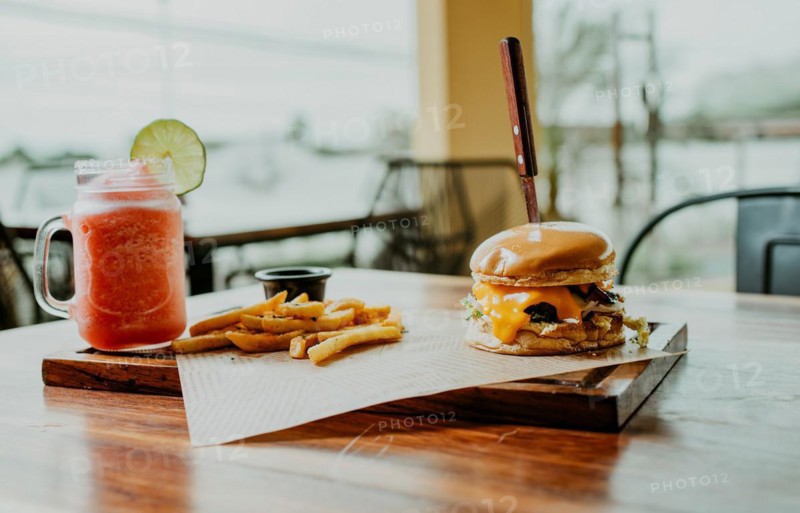 Delicious Hamburger with fries and strawberry cocktail served on a wooden table. Hamburger with strawberry cocktail served on table