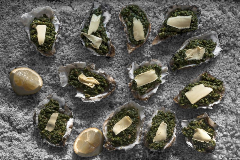 Oysters au gratin with spinach and cheese, recipe a la Rockefeller, decorated with coarse salt, France, Europe