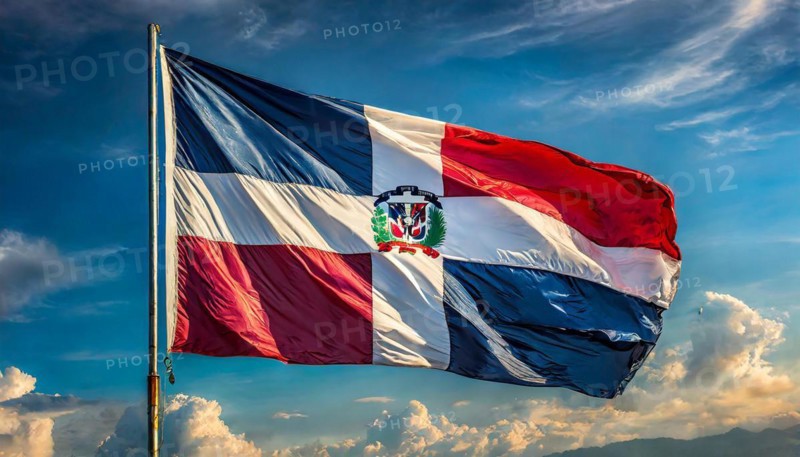The flag of the Dominican Republic flutters in the wind, isolated against a blue sky