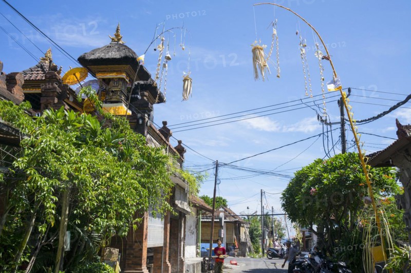 Ornate jewellery woven from palm leaves on bamboo poles, on a village street in Amed, Karangasem, north-east Bali, Indonesia, Asia
