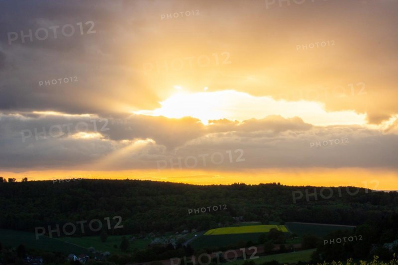 Landscape at sunrise. Beautiful morning landscape with fresh yellow rape fields in spring. Small castle in the yellow fields on a hill. Historic Ronneburg Castle in the middle of nature, Ronneburg, Hesse, Germany, Europe