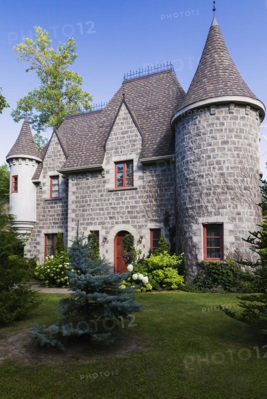 2006 reproduction of a 16th century grey stone and mortar Renaissance castle style residential home facade in summer, Quebec, Canada, North America