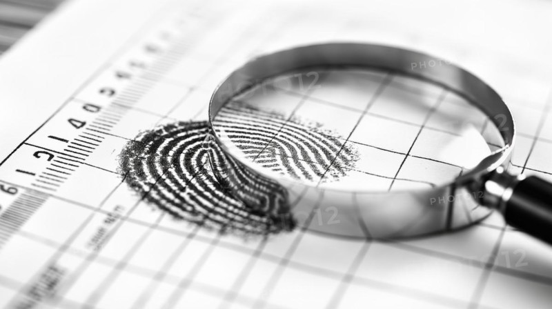 Magnifying glass resting on a fingerprint on paper. generative AI, AI generated