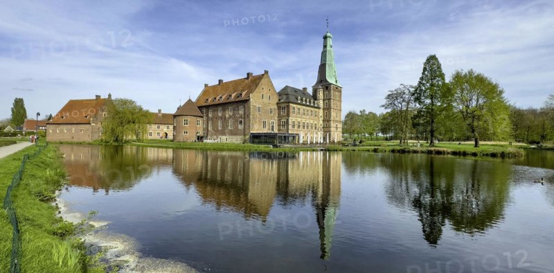 View over wide moat to historic moated castle from Renaissance Raesfeld Castle reflected in moat in spring, Freiheit Raesfeld, Muensterland, North Rhine-Westphalia, Germany, Europe