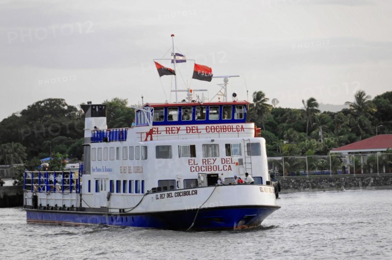 Lake Nicaragua, Ometepe Island in the background, Illuminated ferry at the dock at dusk with a clear sky and the sign 'EL REY DEL COCIBOLCA', Nicaragua, Central America, Central America