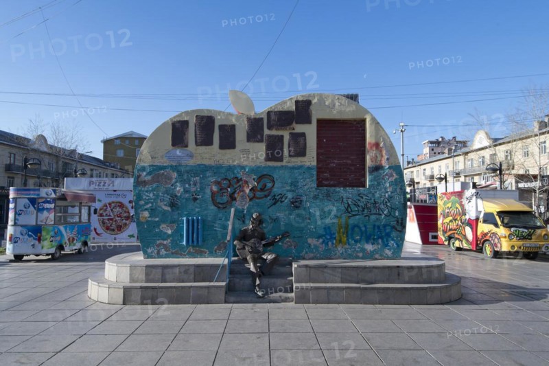 Beatles monument with graffiti and slogans on Tserendorjiin Gudamj Street in front of street food carts, capital Ulan Bator, Ulanbator, Ulaanbaatar, Mongolia, Asia