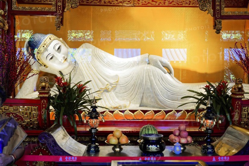 Reclining Jade Buddha, Jade Buddha Temple, Shanghai, Buddha at the altar surrounded by offerings and floral decorations in a peaceful mood, Shanghai, China, Asia