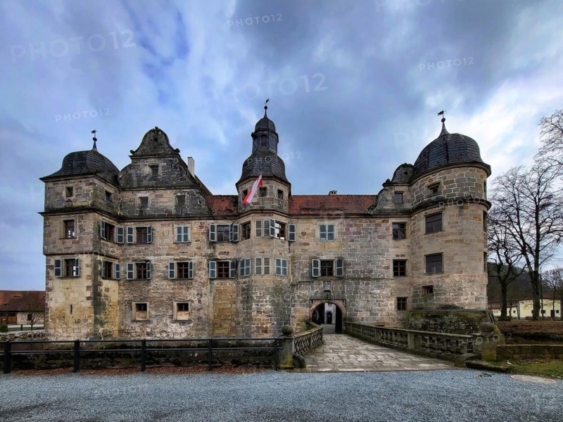 Mitwitz moated castle under a cloudy sky. Mitwitz, Kronach, Upper Franconia, Bavaria, Germany, Europe