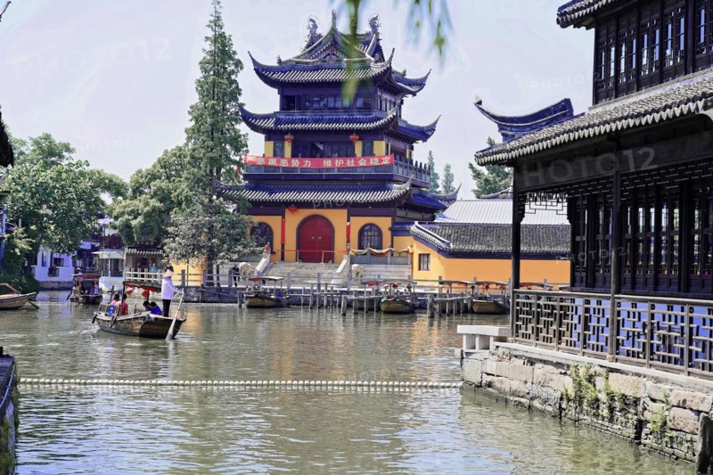 Excursion to Zhujiajiao Water Village, Shanghai, China, Asia, Traditional Chinese building with pagoda roof on a quiet water canal with a boat, Asia