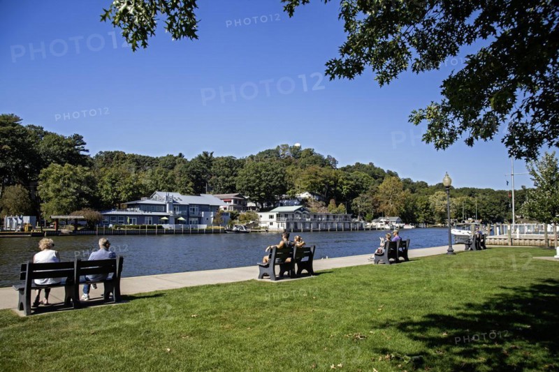 Saugatuck, Michigan, A town on the shore of Lake Michigan that thrives on tourism. The town has many art galleries, unique shops, and restaurants. People relax on benches along the Kalamazoo River