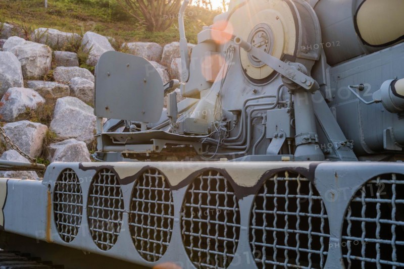 Side view of camouflaged army tank with vents above track and closeup view of chair on rear portion of vehicle in Nonsan, South Korea, Asia