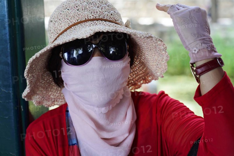 New Summer Palace, Beijing, China, Asia, A woman stylishly protects herself from the sun with a hat and scarf, Beijing, Asia