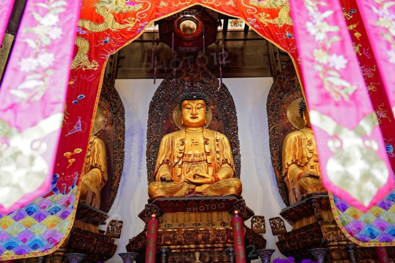 Jade Buddha Temple, Shanghai, Buddha in meditation posture behind colourful curtains on a richly decorated altar, Shanghai, China, Asia