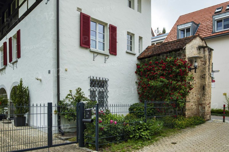 A section of the medieval town wall protrudes from a residential building, Old Town of Isny im Allgaeu, Baden-Wuerttemberg, Germany, Europe