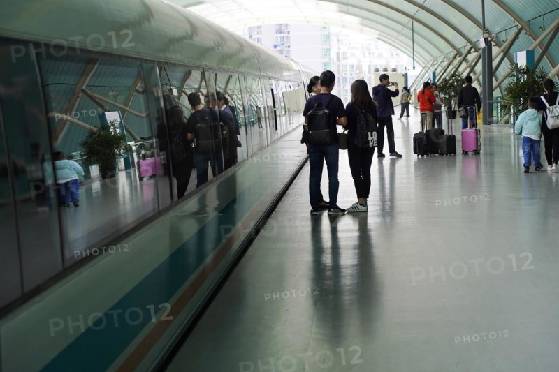 Shanghai Transrapid Maglev Shanghai Maglev Train Station Station, Shanghai, China, Asia, Travellers with luggage walk through a brightly lit glass tunnel, Asia