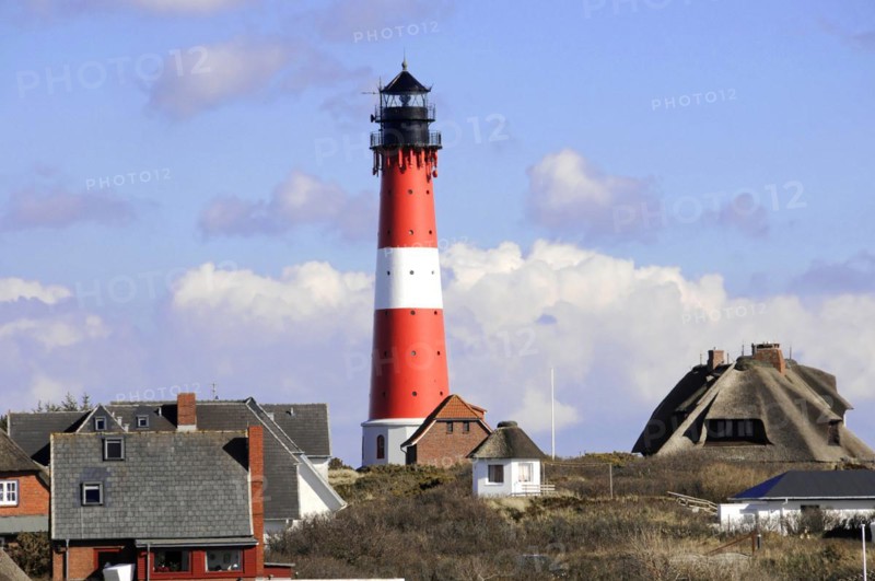 Lighthouse, Hoernum, Sylt, North Frisian Island, Schleswig Holstein, A striking red and white striped lighthouse stands behind a row of houses, Sylt, North Frisian Island, Schleswig Holstein, Germany, Europe