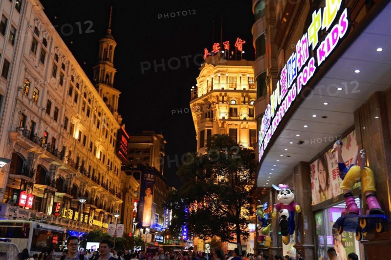 Evening stroll through Shanghai to the sights, Shanghai, Night view of the city with brightly lit billboards and passers-by on a busy shopping street, Shanghai, People's Republic of China